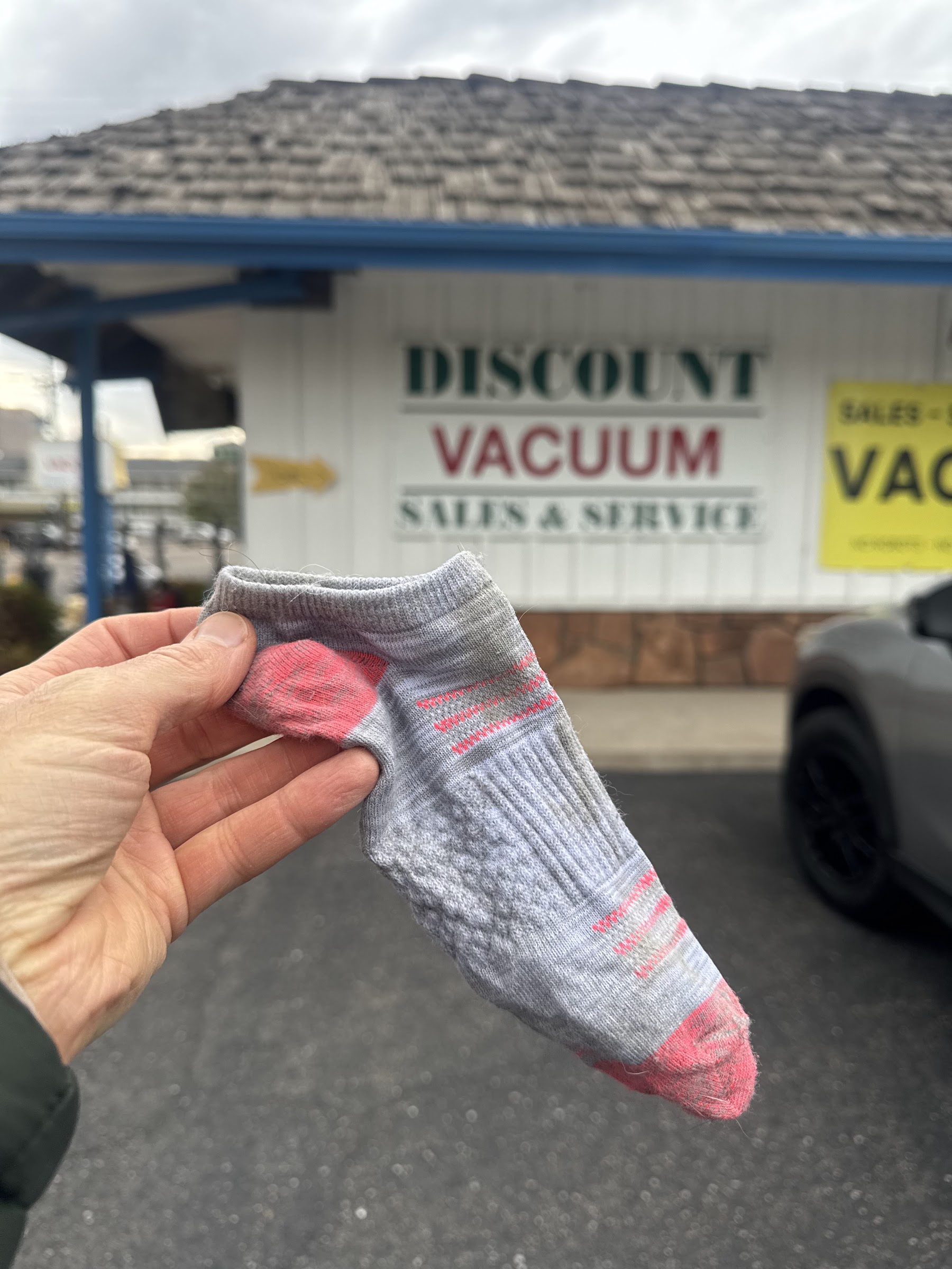Vacuum part held outside the Discount Vacuum storefront